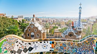 Parc Guell in Barcelona Blick auf die Mosaikkunst im Park Guell und die Skyline von Barcelona