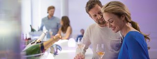Ein Paar genießt einen Champagner an der Spray Bar auf AIDAprima
