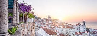 Panoramablick auf Lissabon mit der aufgehenden Sonne im Hintergrund