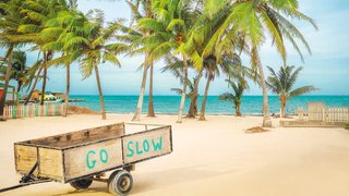Anhänger mit der Aufschrift Go Slow am Strand Anhänger mit der Aufschrift Go Slow am Strand