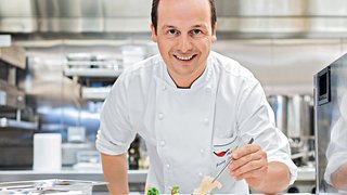 Ein Koch richtet das Essen an