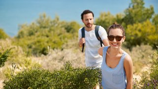 Pärchen beim Wandern an der Küste Spaniens Ein Pärchen wandert durch die grüne Küstenlandschaft in der Nähe von Cadiz