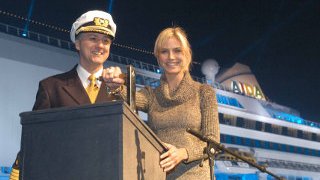 Taufe von AIDAaura Heidi Klum und ein Offizier stehen am Schalthebel für die Taufe vor AIDAaura