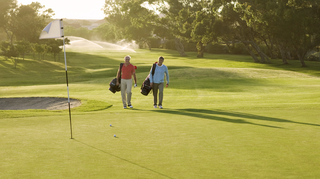 Zwei Männer laufen auf einem Golfplatz